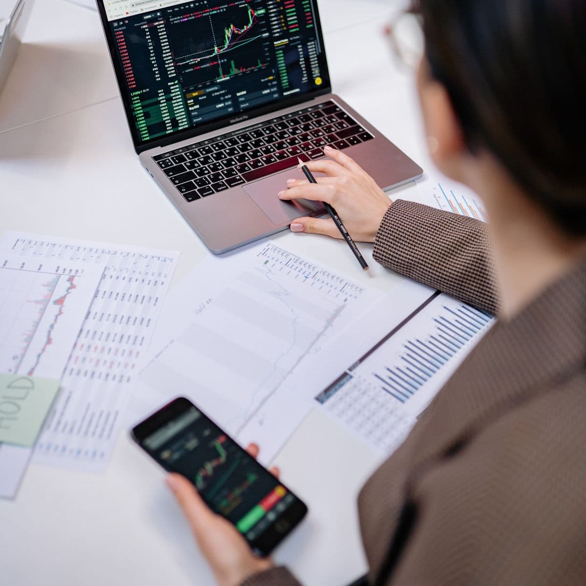 Financial charts on a laptop and phone