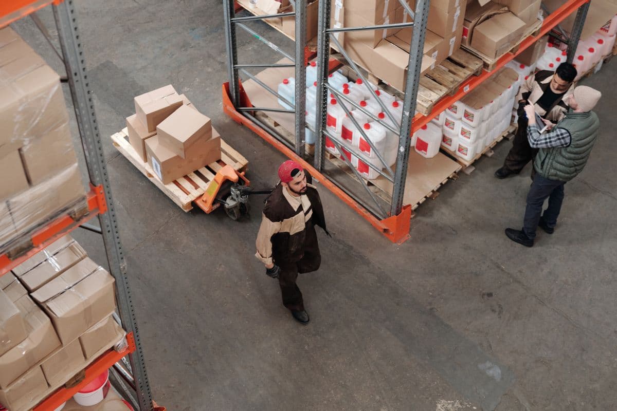 Warehouse worker moving boxes on a pallet jack